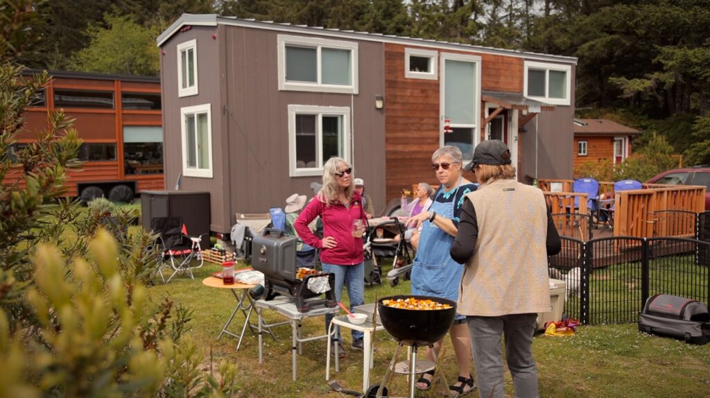 Outdoor potluck dinner party at Tiny Tranquility - clikc ot watch tour of this tiny home community!