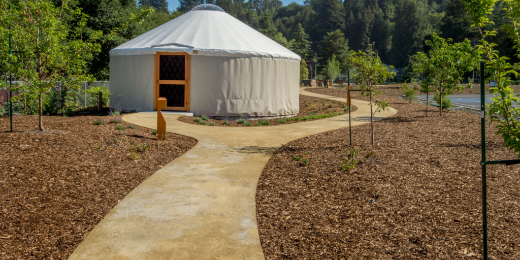 A path leading up to a yurt home, tucked away in nature