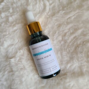 A bottle of facial serum tinted blue from being infused with blue tantsy flowers and other herbs